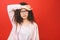 Portrait of beautiful student woman tired at work, isolated on a red background