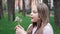 Portrait of a beautiful teenage girl blowing on the ripened dandelion in a spring or summer park. Slow motion video