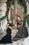 Portrait of beautiful twins young women in gorgeous evening dresses over christmas background