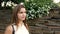 Portrait of the beautiful woman against the background of a wall from stones and flowers. woman walking in the stone