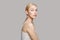 Portrait of beautiful woman with blonde hair standing sideways isolated on grey. Beauty, cosmetics, skincare, glamour