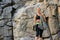 Portrait of Beautiful Woman Climber Holding the Rope near the Rock in the Mountains. Adventure and Extreme Sport Concept