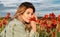 Portrait of a beautiful woman on flowering poppy field. Summer holidays on nature. Girl on poppies meadow with poppys