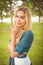 Portrait of beautiful woman with hand on chin while standing on grass