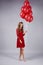 Portrait of beautiful woman holding a bunch of balloons