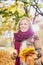 Portrait of beautiful woman holding maple leaves in park