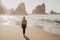 Portrait of beautiful woman with light brown hair posing on rocky Ursa beach on sunset. Smiling looking to the camera