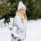 Portrait of beautiful woman at outdoor ice-skating rink holding skates