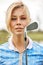 Portrait of a beautiful woman playing golf on a green field outdoors background. The concept of golf, the pursuit of