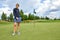 Portrait of a beautiful woman playing golf on a green field outdoors background. The concept of golf, the pursuit of