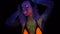 Portrait of Beautiful Woman with Purple Hair Dancing in Neon UV Light. Model Girl with Fluorescent Creative Psychedelic