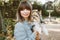 Portrait of a beautiful woman with rare little size purebreed dog - Biewer Terrier. Girl is walking in the park with her cute