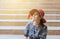 Portrait of beautiful woman with red hat sitting on stair in the center city,Happy and smiling emotion,Female with positive attitu