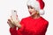 Portrait of a beautiful woman in a red hat and a sweater does selfie on a mobile phone