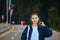 Portrait of a beautiful woman in a shirt on the street standing on the road on a background of forest and posing for the camera