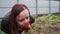 Portrait of a beautiful woman sniffs the rose in park. Close-up face and rose. Side view.