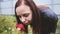 Portrait of a beautiful woman sniffs the rose in park. Close-up face and rose. Side view.