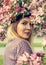 Portrait of a beautiful woman among spring foliage and flowers