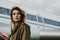 Portrait of beautiful woman standing on ramp against the plane.