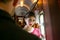 Portrait of beautiful woman in vintage dress standing in corridor of locomotive train with officer in uniform watching