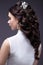 Portrait of a beautiful woman in a wedding dress in the image of the bride. Hairstyle back view