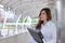 Portrait of beautiful young Asian secretary woman holding ring binder at sidewalk of office with copy space.