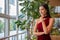 portrait of Beautiful young asian woman in red dress standing and looking out the window . elegant lady model positive thinking