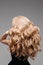 Portrait Of Beautiful Young Blond Woman With Long Wavy Hair. Back View