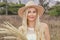 Portrait. Beautiful young blonde in a hat posing on the prairie in the field.