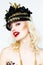 Portrait of beautiful young blonde woman in extravagant hat on white background