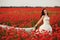 Portrait of beautiful young bride in field full of red poppies