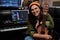 Portrait of beautiful young brunette, female artist smiling at camera while sitting with ukulele in recording studio