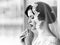 Portrait of beautiful young brunette sensual pensive bride in white lace dress and veil on head. Dream girl. Young bride