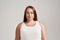 Portrait of a beautiful young caucasian plus size woman wearing white shirt, looking at camera while posing isolated