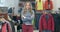 Portrait of beautiful young Caucasian woman posing in clothing shop. Charming female shopper crossing hands and smiling