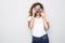 Portrait of beautiful young curly mixed race woman photographer isolated over white background holding camera.