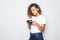 Portrait of beautiful young curly mixed race woman photographer isolated over white background holding camera.