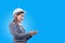 Portrait of beautiful young engineer woman wear a white safety helmet smiling with commitment to success on blue background