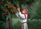 Portrait of a beautiful young girl in folk dress near a Rowan tree