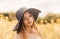 Portrait of a beautiful young girl in a hat against the background of a rapeseed field