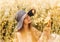 Portrait of a beautiful young girl in a hat against the background of a rapeseed field