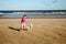 Portrait of a beautiful young girl and her puppy running on the beach