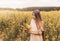 Portrait of  beautiful young girl with long hair against the background of rapeseed flowers. Youth and nature