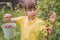 Portrait of beautiful young girl picking redcurrant outdoors in the garden.  Agriculture, health, bio food concept