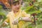 Portrait of beautiful young girl picking redcurrant outdoors in the garden. Selective focus