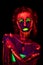 Portrait of a beautiful young girl with ultraviolet paint on her body. Pretty woman with glowing bodyart in black