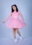 Portrait Of Beautiful Young girle Standing Against blue Background,girl in a pink dress,Happy cheery smiling young cute girl