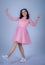 Portrait Of Beautiful Young girle Standing Against blue Background,girl in a pink dress,Happy cheery smiling young cute girl