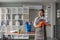 Portrait of a beautiful young housewife smiling and happy, holding cleaning supplies in the office. cleaning supplies