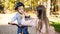 Portrait of beautiful young mother adjusting safety helmet on her son`s head before riding a bicycle at park